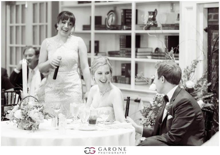 Bride in a white dress holding a microphone at a wedding reception.