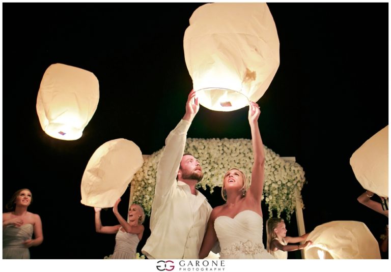 Couple releases glowing sky lantern at night celebration.