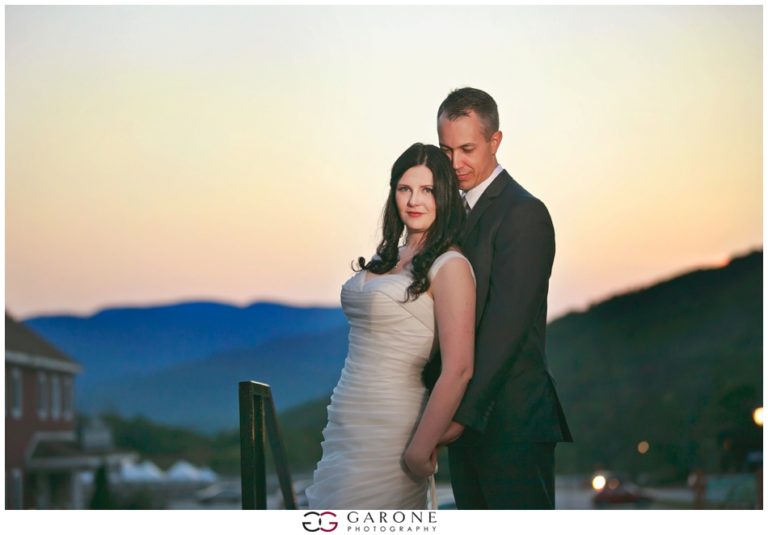 A couple posing together outdoors during sunset with mountains in the background.