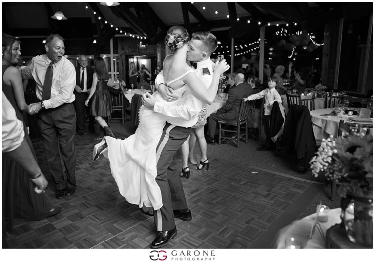 Bride and groom share a joyful dance lift at their wedding reception.