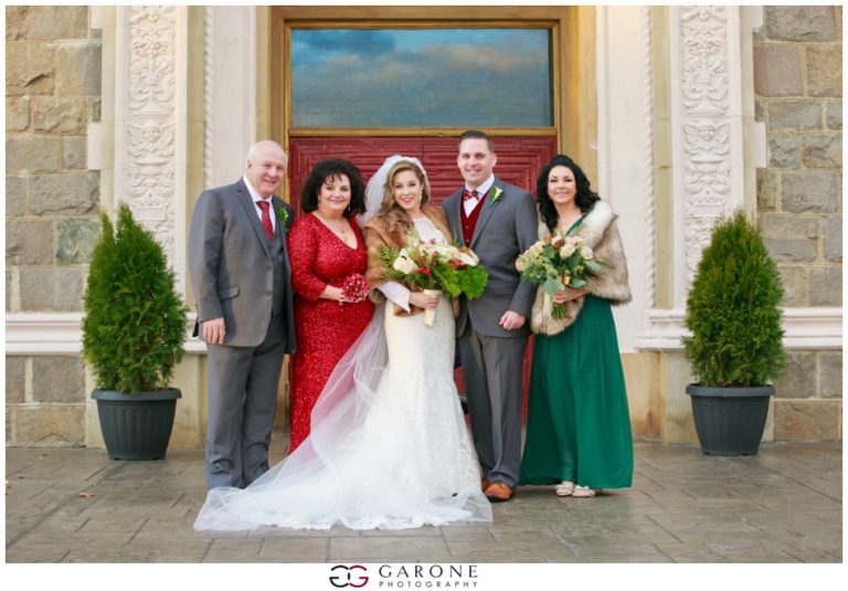 A joyful wedding couple with family and friends posing outdoors.