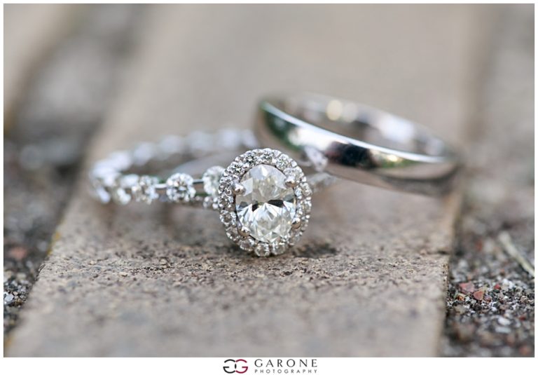 Close-up of elegant diamond engagement and wedding rings on a textured surface.