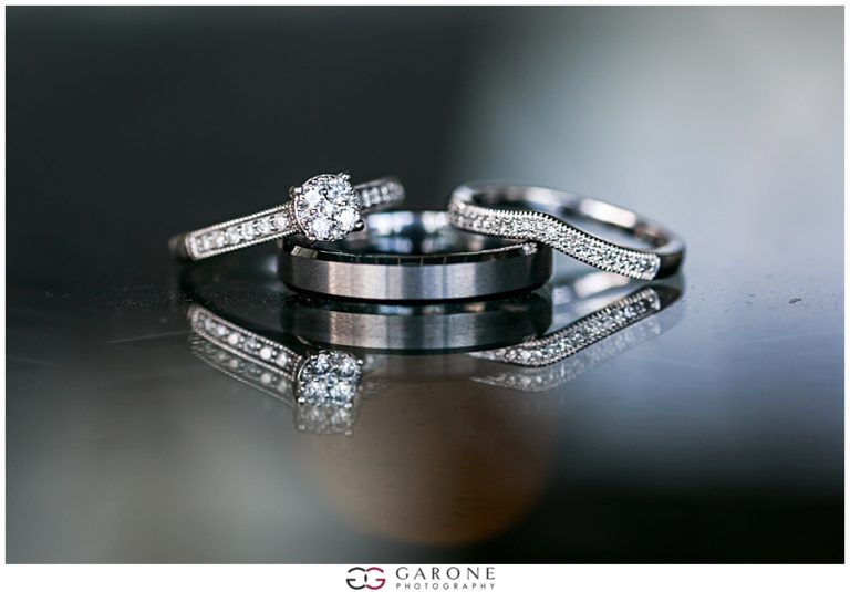 Elegant black and silver rings with sparkling diamonds on reflective surface.