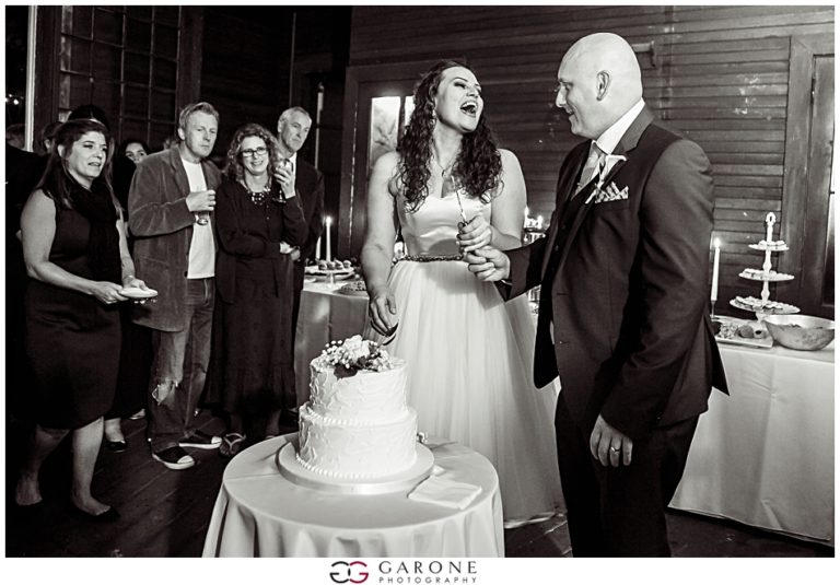 Bride and groom sharing a joyful moment at their wedding with guests applauding.