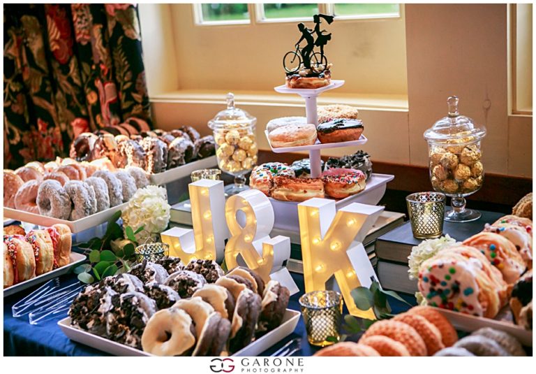 A dessert table with donuts, pastries, and illuminated initials R and K.
