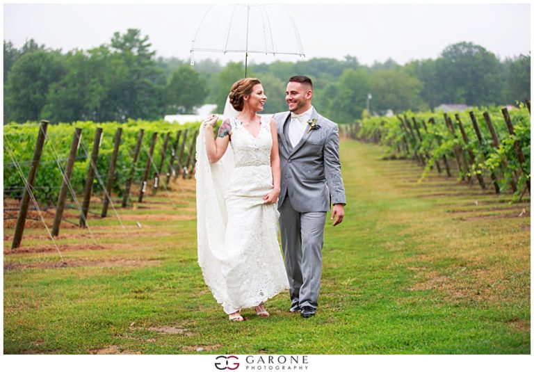 Newlywed couple joyfully walking through a vineyard on their wedding day.