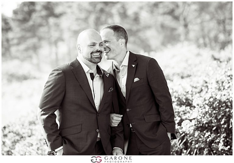 Two men in suits sharing a joyful moment outdoors.