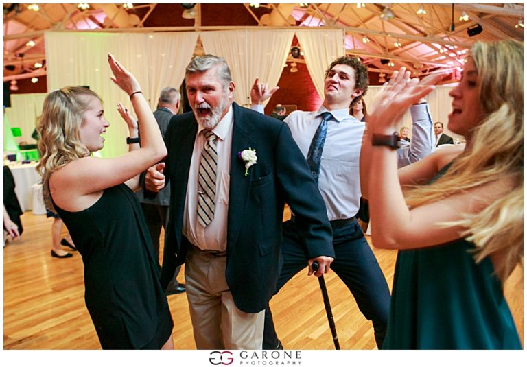 People celebrating energetically at an indoor event with wooden ceiling beams.