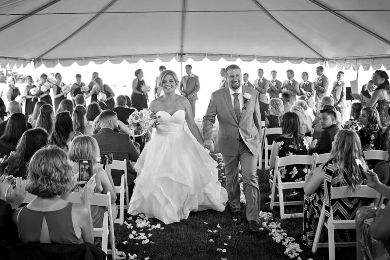 Bride and groom joyfully walking down the aisle after their wedding ceremony.