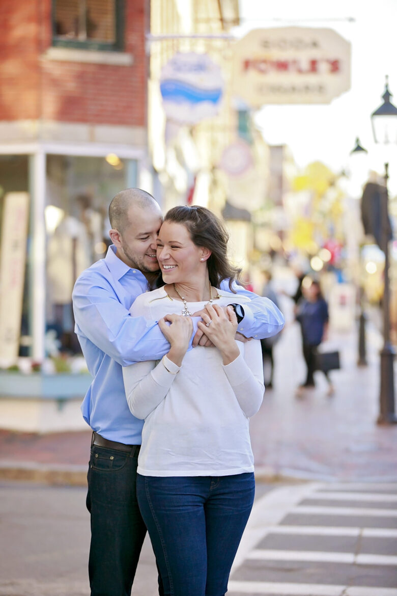 Couple sharing a joyful embrace on a sunny street.